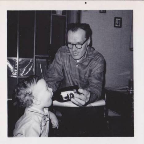Grampa, here busted by a photographer, feeding me a sip of O'Keefe. The bottle gives some sense of scale - have a look at how big his hands were.